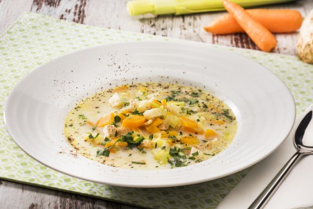 Haferflockensuppe mit Gemüse - In einem tiefen weißen Suppenteller ist eine Portion der Haferflockensuppe angerichtet. Das Gemüse ist darin gut zu erkennen. Über die Suppe ist Petersilie und Pfeffer gestreut. (Foto: VrK/Alexander Stiegler - Nicht zur freien Verwendung)