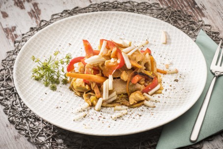 Hühnerbrustfilets mit Birnenspalten - Auf einem runden weißen Teller mit Musterung sind die Geflügelstreifen mit Paprika, Birne und Mandelsplitter angerichtet. (Foto: VrK/Alexander Stiegler - Nicht zur freien Verwendung)