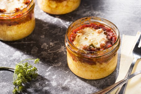 Maispizza - Auf grauem Untergrund steht ein Glas, in welchem die verschiedenen Zutaten geschichtet wurden; abgeschlossen mit geschmolzenem Käse. (Foto: VrK/Alexander Stiegler - Nicht zur freien Verwendung)