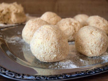 Topfenknödel - Auf einer silbernen Platte liegen einige fertig zubereitete Topfenknödel die leicht mit Staubzucker bestreut sind. (Foto: VrK/DI Carina Laschober- Luif - Nicht zur freien Verwendung)