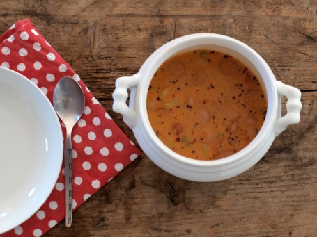 Würstlgulasch - Auf einem Holztisch steht eine weiße Schüssel mit hellbraun/orangefarbenem Gulasch (Foto: Vrk/Laschober-Luif - Nicht zur freien Verwendung)