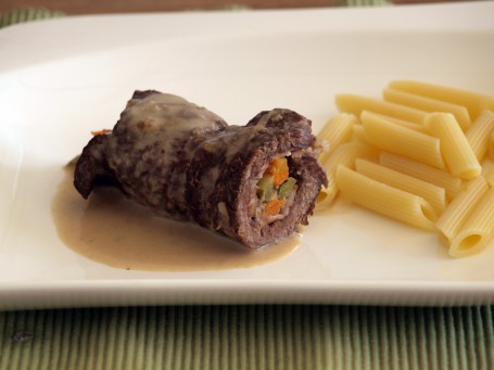 Rindsrouladen - Auf einem weißen Teller liegt eine gedünstete, braune aufgeschnittene und gefüllte Rindsroulade, daneben einige gelbe Röhrennudeln und braune Sauce (Foto: VrK/Laschober-Luif - Nicht zur freien Verwendung)