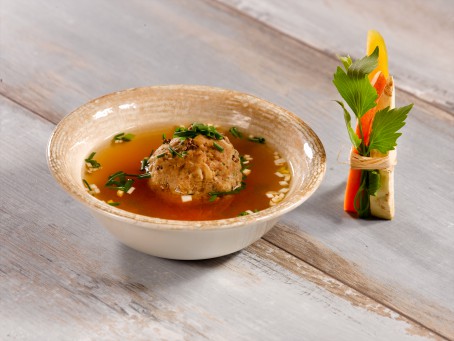 Leberknödel gekocht und gebacken - In einer braunen Schale liegt ein gekochter Leberknödel in einer goldbraunen Brühe, ganiert mit Schnittlauch. (Foto: VrK/Dall - Nicht zur freien Verwendung)