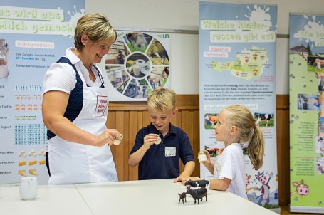 Butter shaken - Auf dem Bild sieht man eine Seminarbäuerin die mit zwei Kindern mit Hilfe von kleinen Gefäßen Butter schüttelt. (Foto: Carletto Photography, www.carletto.at - Nicht zur freien Verwendung)