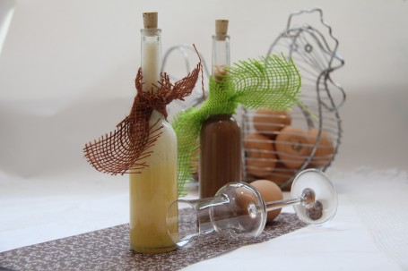 Eierlikör - Auf dem Bild befinden sich eine Flasche Eierlikör und eine Flasche Schokolikör, sowie ein Schnapsglas und Eier im Hintergrund. (Foto: Elisabeth Heidegger - Nicht zur freien Verwendung)