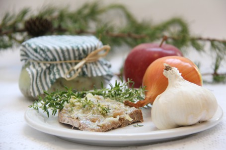 Würziges Kräuter-Grammelschmalz - Auf dem Bild sieht man das fertige Kräuter-Grammelschmalz. Davor ist ein Brot mit dem Aufstrich sowie zwei Ziebeln. (Foto: Elisabeth Heidegger - Nicht zur freien Verwendung)