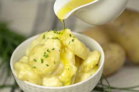 Leinöl-Erdäpfel - Erdäpfel in weißer Schüssel garniert mit Schnittlauch die mit frischem Leinöl übergossen werden (Foto: Tobias Schneider-Lenz - Nicht zur freien Verwendung)