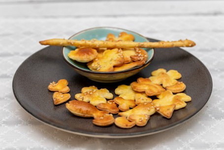 Erdäpfelplätzchen - Goldgelb gebackene Plätzen in verschiedenen Formen platziert auf einem dunklen Teller (Foto: VrK/Achim Mandler Photography - Nicht zur freien Verwendung)