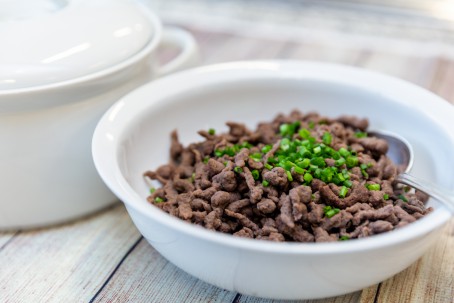 Leberreis - Braune längliche Leberspätzle garniert mit Kräutern in einer weißen Schale (Foto: VrK/Achim Mandler Photography - Nicht zur freien Verwendung)