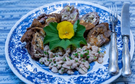 Rindsrouladen angerichtet - Auf einem blau verziertem Teller sind Dinkelspätzle im Vordergrund und die aufgeschnittene Rindsroulade im Hintergrund schön angerichtet. Die Rindsroulade liegt in einem Halbkreis. Verziert ist das Gericht mit einem grünen Blatt und einer gelben Blüte. Die Spätzle sind mit Schnittlauch bestreut. Am rechten Rand des Tellers liegen Messer und Gabel bereit. (Foto: VrK/Achim Mandler Photography - Nicht zur freien Verwendung)